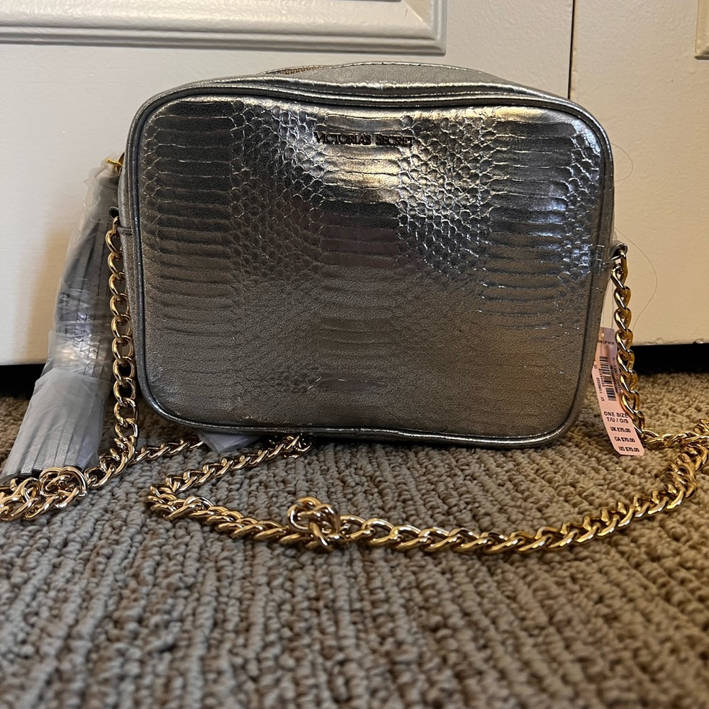 Silver shoulder bag by Victoria Secret with gold chain.